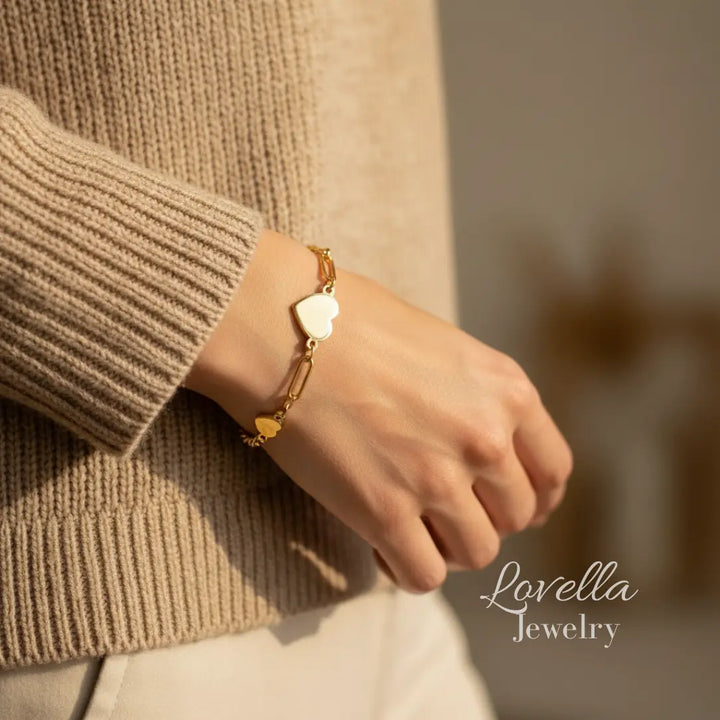 Gold bracelet on a wrist with a blurred background and 'Lovella Jewelry' branding.