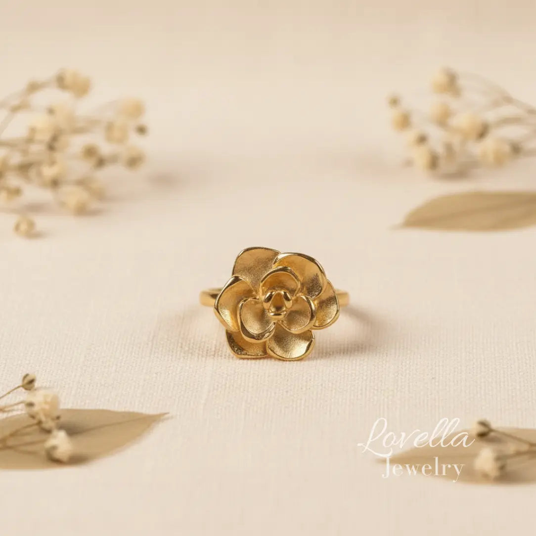 Gold flower-shaped ring on a beige fabric background with 'Lavelia Jewelry' branding.