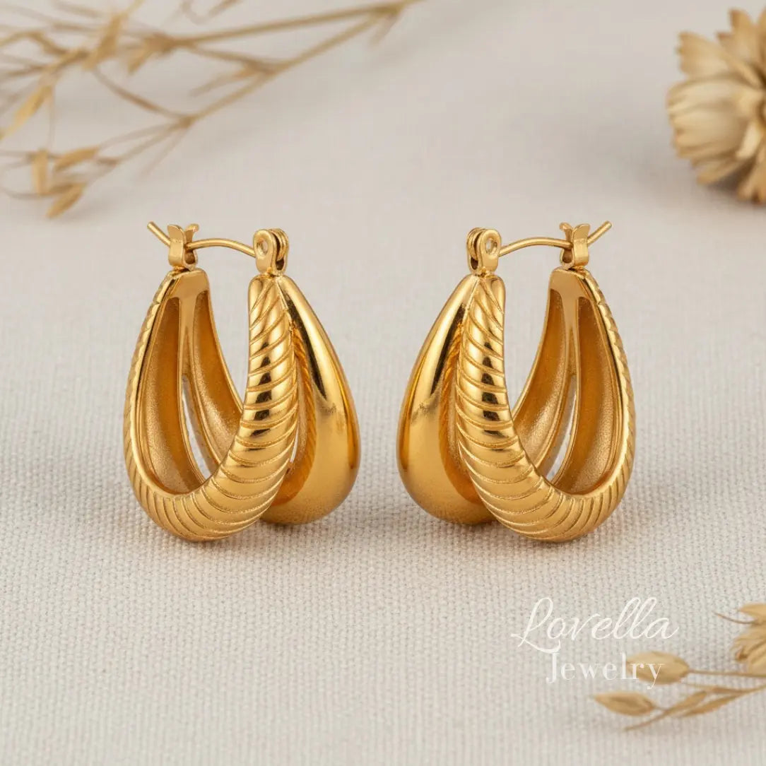 Gold hoop earrings on a beige background with 'Lovella' branding.