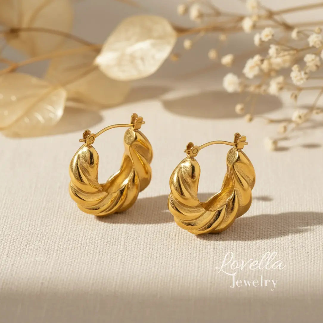 Gold hoop earrings on a beige surface with decorative elements