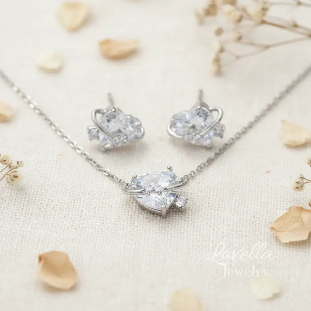 Silver jewelry set with necklace and earrings on a light background