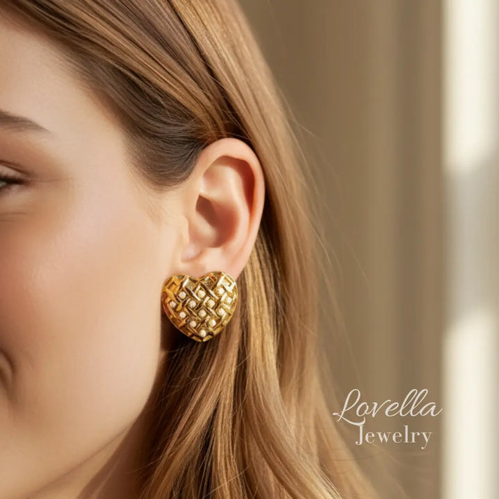 Close-up of a person wearing gold earrings with 'Lovella Jewelry' branding.