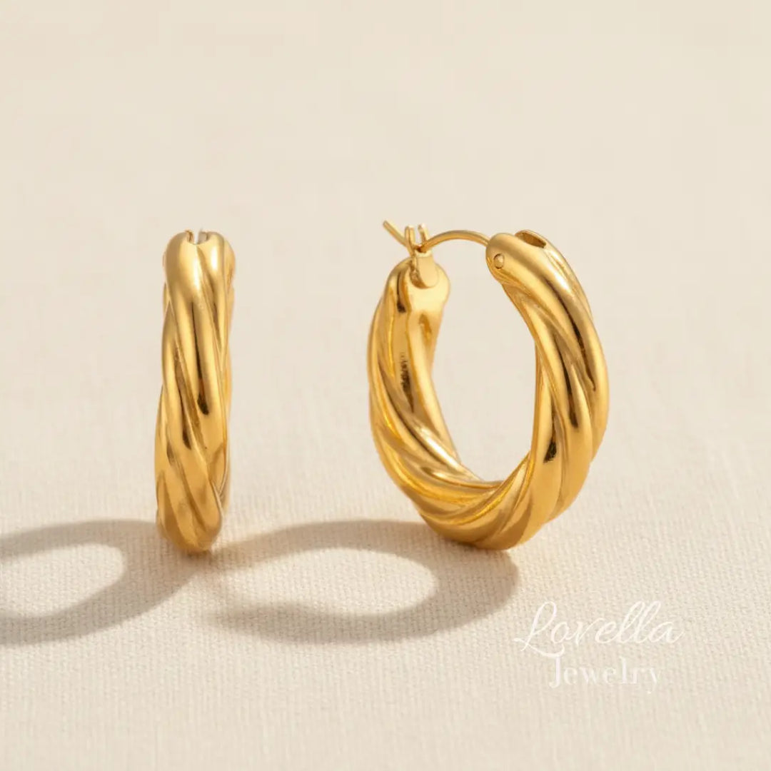 Gold hoop earrings on a beige background with 'Lovella' branding.