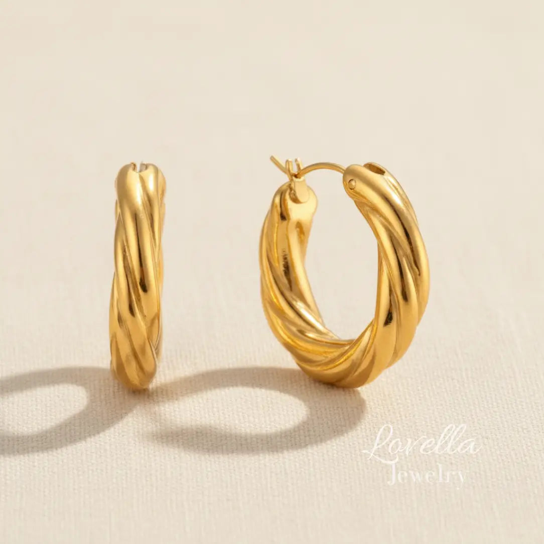 Gold hoop earrings on a beige background with 'Lovella' branding.