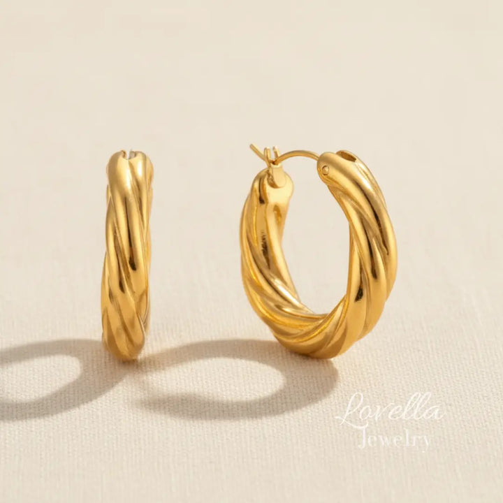 Gold hoop earrings on a beige background with 'Lovella' branding.