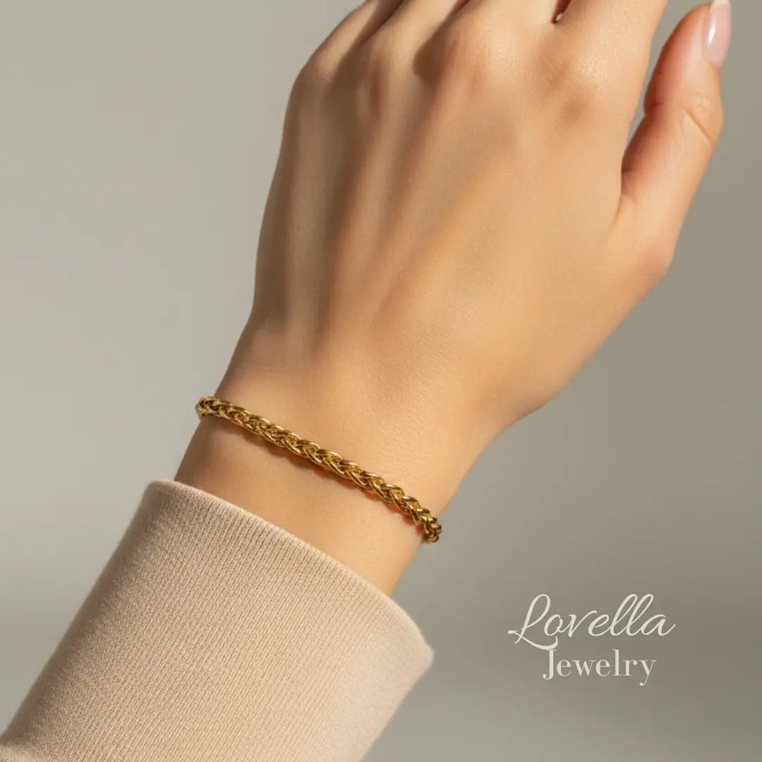 Gold bracelet on a wrist with 'Lovella Jewelry' branding.