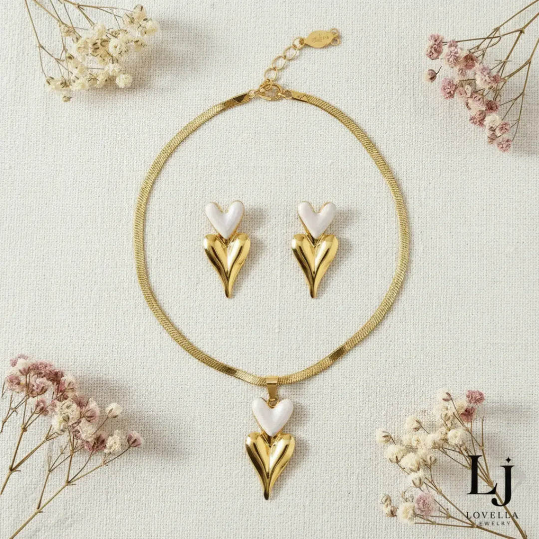 Heart-shaped gold and white jewelry set with dried flowers on a light background