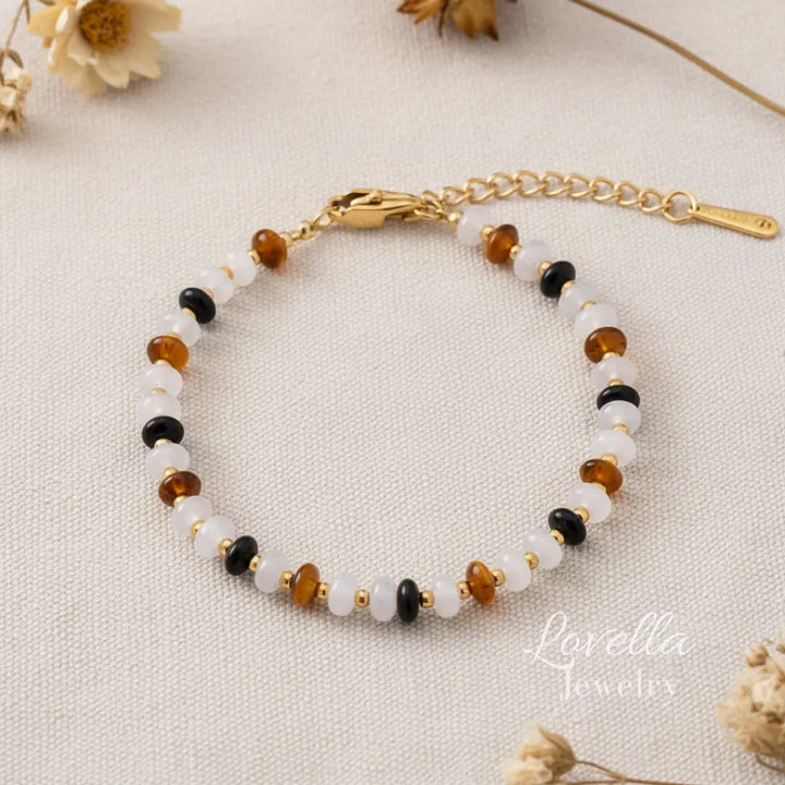 Natural stones bracelet with gold clasp on a beige fabric background, featuring the brand 'Lovella Jewelry'.