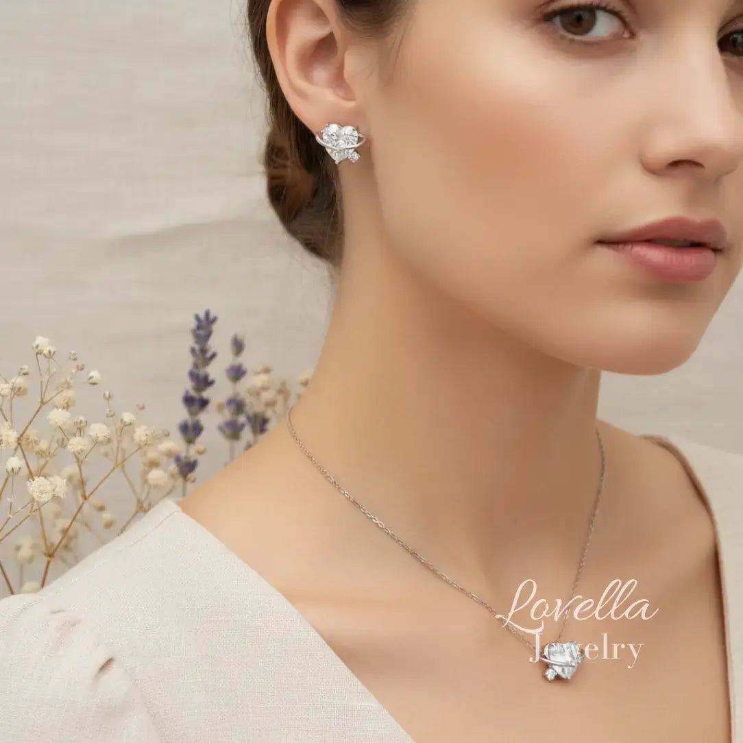 Woman wearing a necklace with a floral design, set against a neutral background with dried flowers.