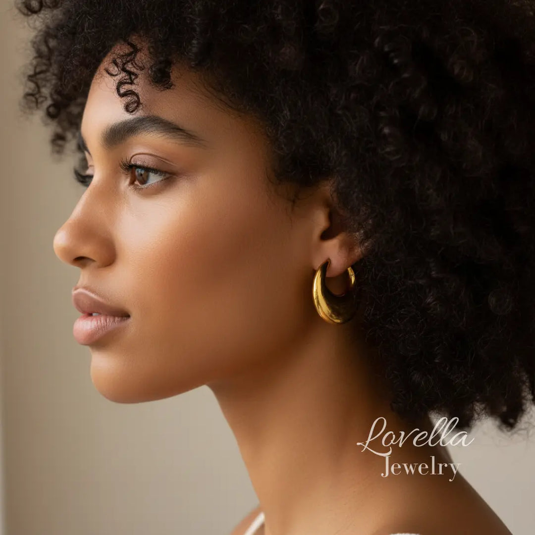 Woman wearing gold hoop earrings with 'Lovella Jewelry' branding.