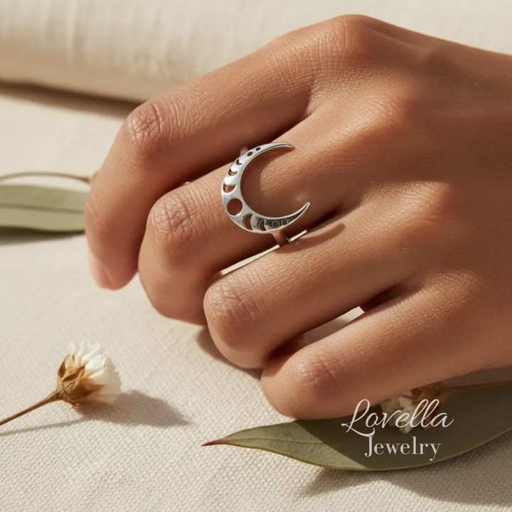 Silver crescent moon ring on a hand with a soft background, featuring Lovella Jewelry.