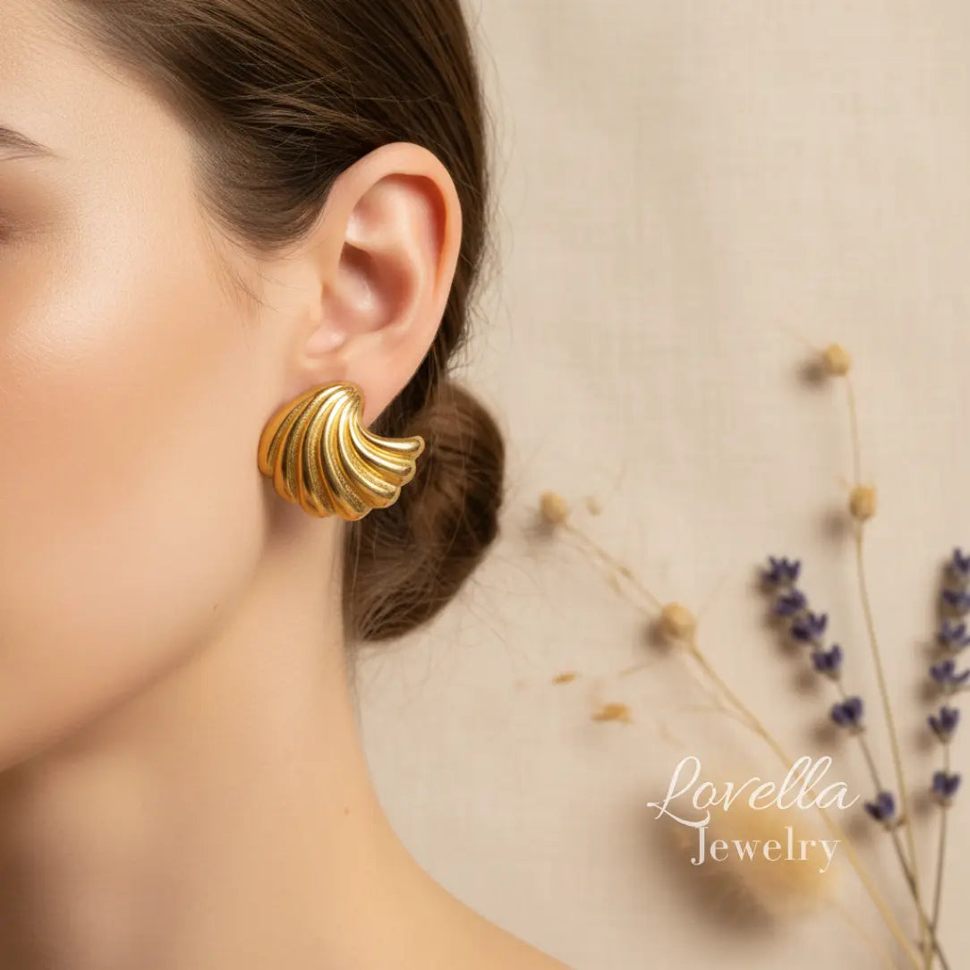 Gold earrings worn by a model with 'Lovella Jewelry' branding.