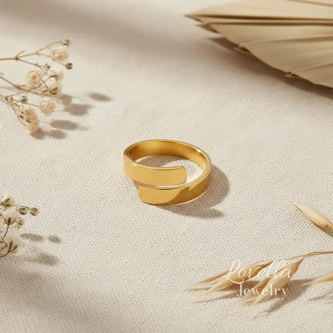 Gold ring on a beige fabric background with dried flowers
