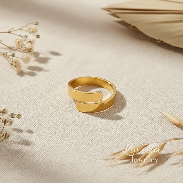 Gold ring on a beige fabric background with dried flowers