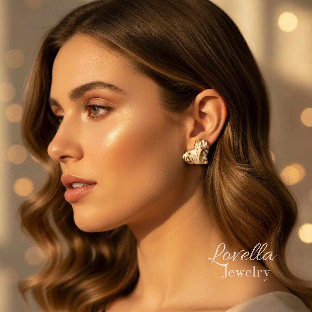 Woman wearing gold earrings with a blurred background and 'Lovella Jewelry' branding.