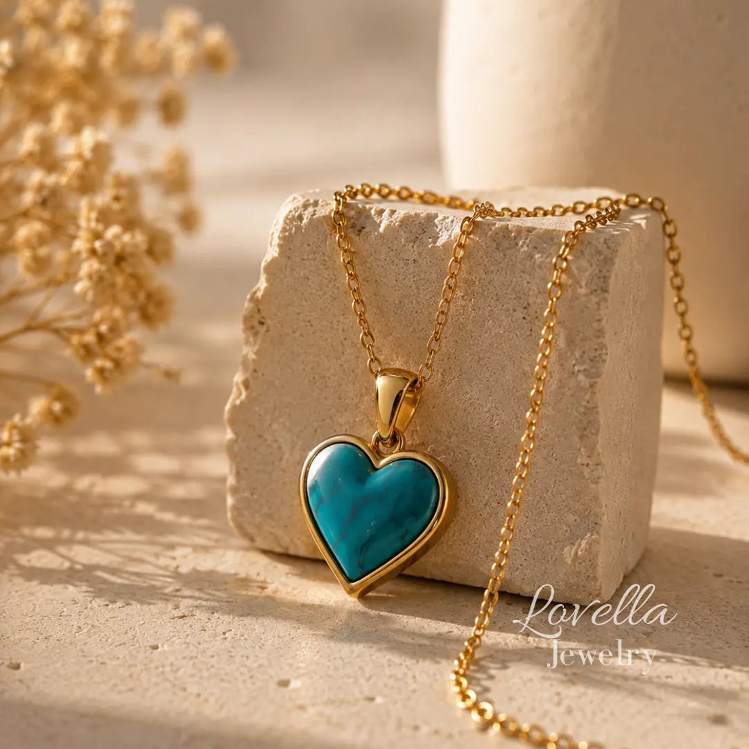 Amore Turquoise Heart Necklace draped over cream stone with heart pendant displayed in front