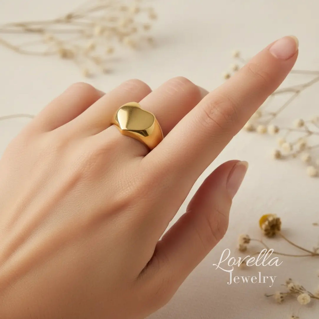 Gold ring on a finger with 'Lovella Jewelry' branding