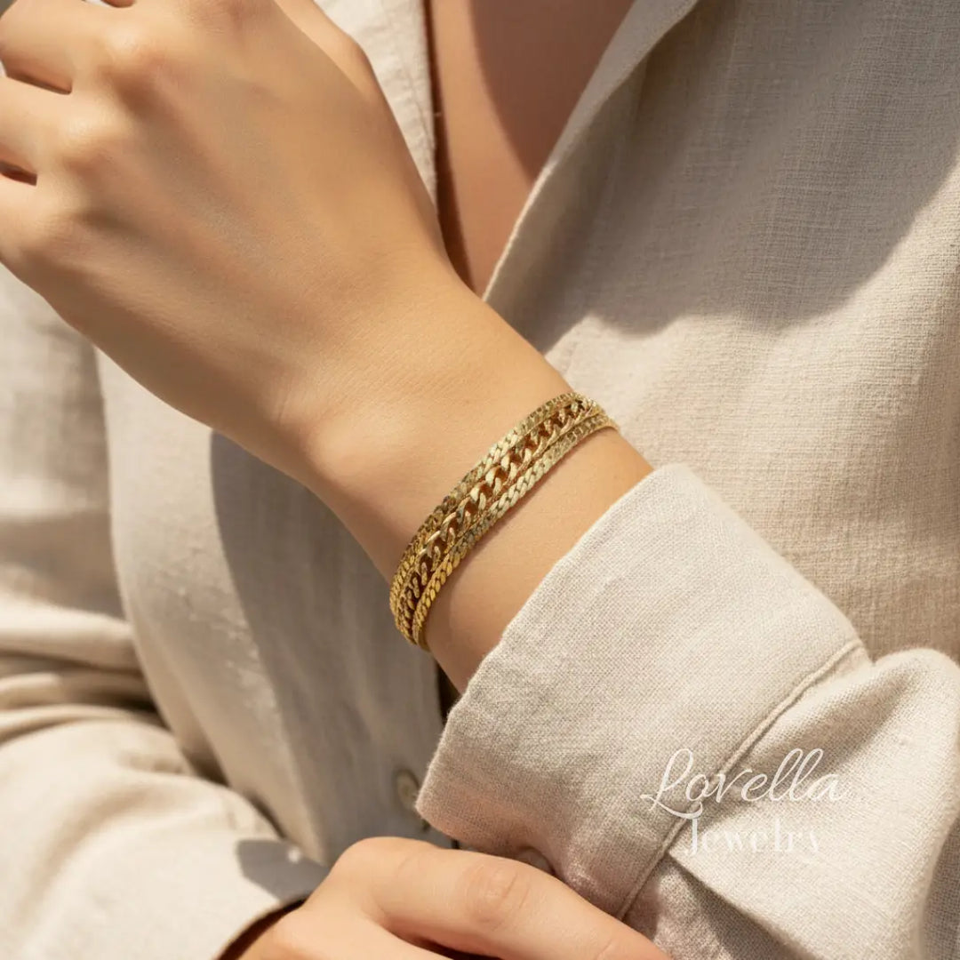 Gold bracelet on a wrist with a neutral background, featuring the brand 'Lovella'.