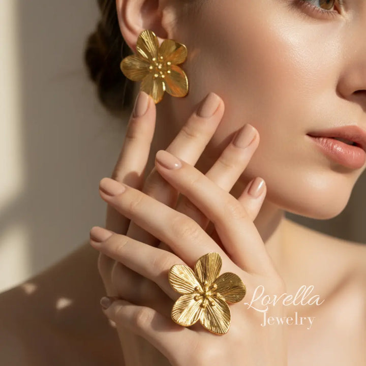 Gold flower earrings worn by a model with 'Lovella Jewelry' branding.