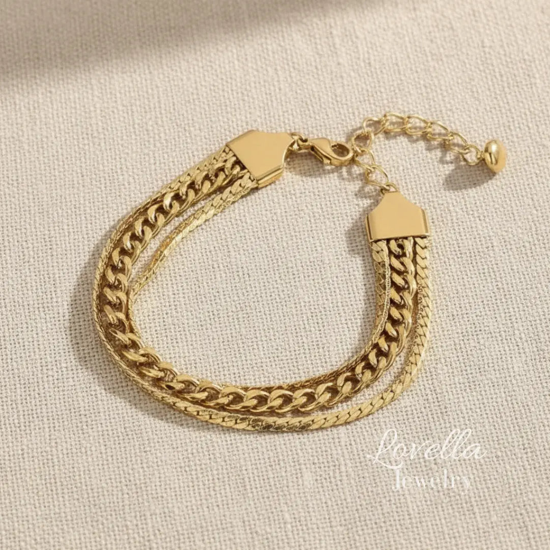 Gold chain bracelet on a textured beige background