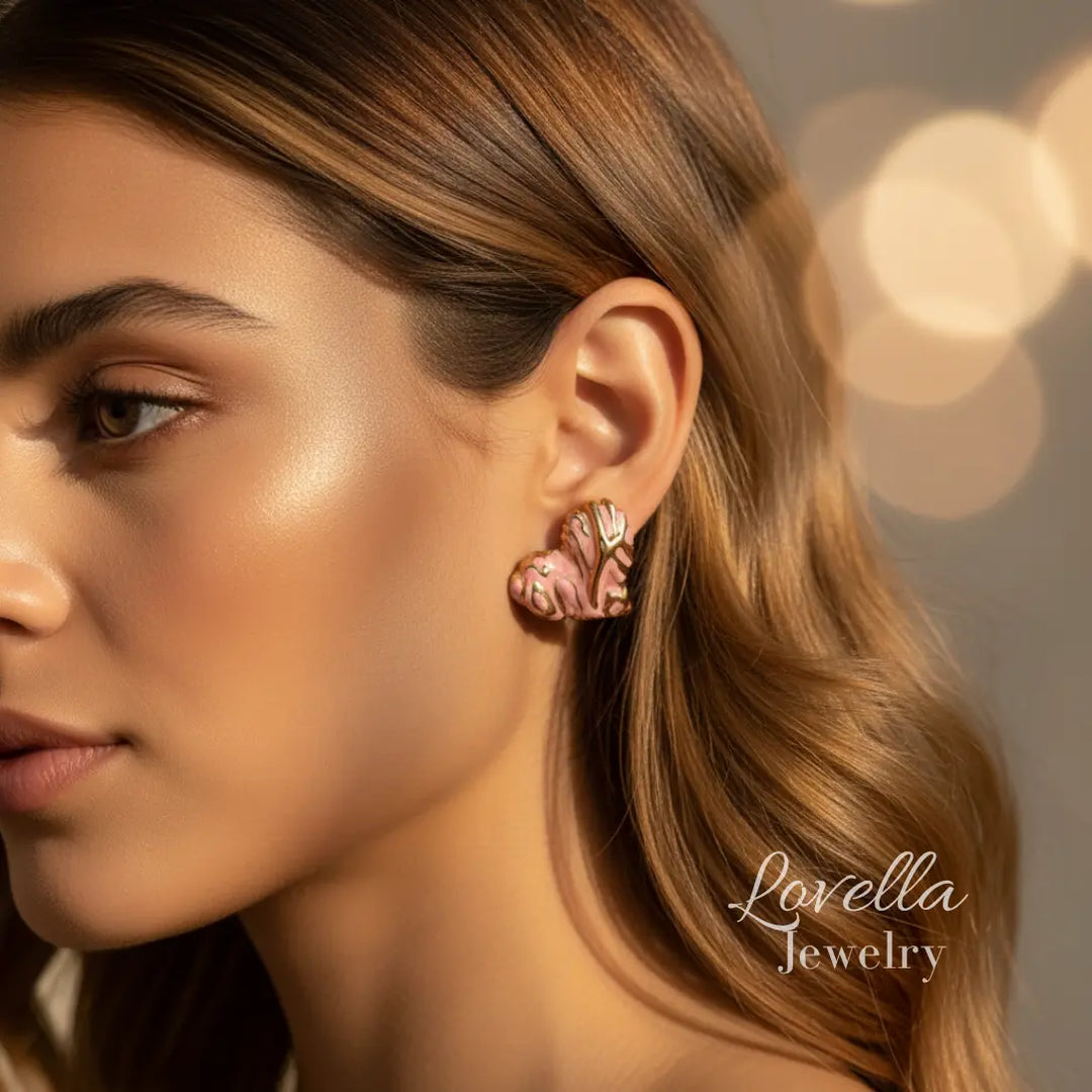 Close-up of a woman wearing pink earrings with a blurred background and 'Lovella Jewelry' branding.