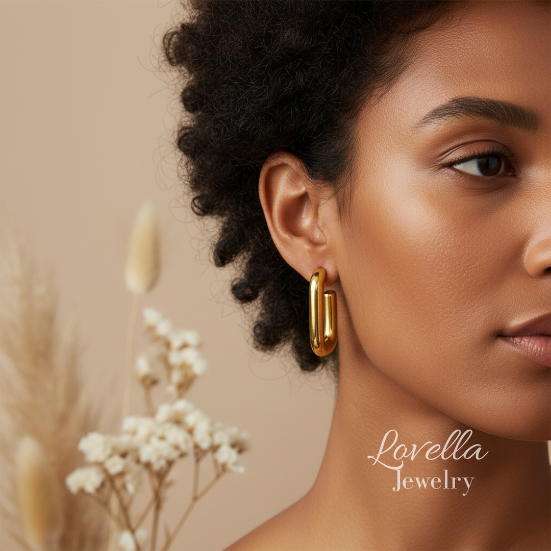 Woman wearing gold earrings with a blurred background and 'Lovella Jewelry' branding.