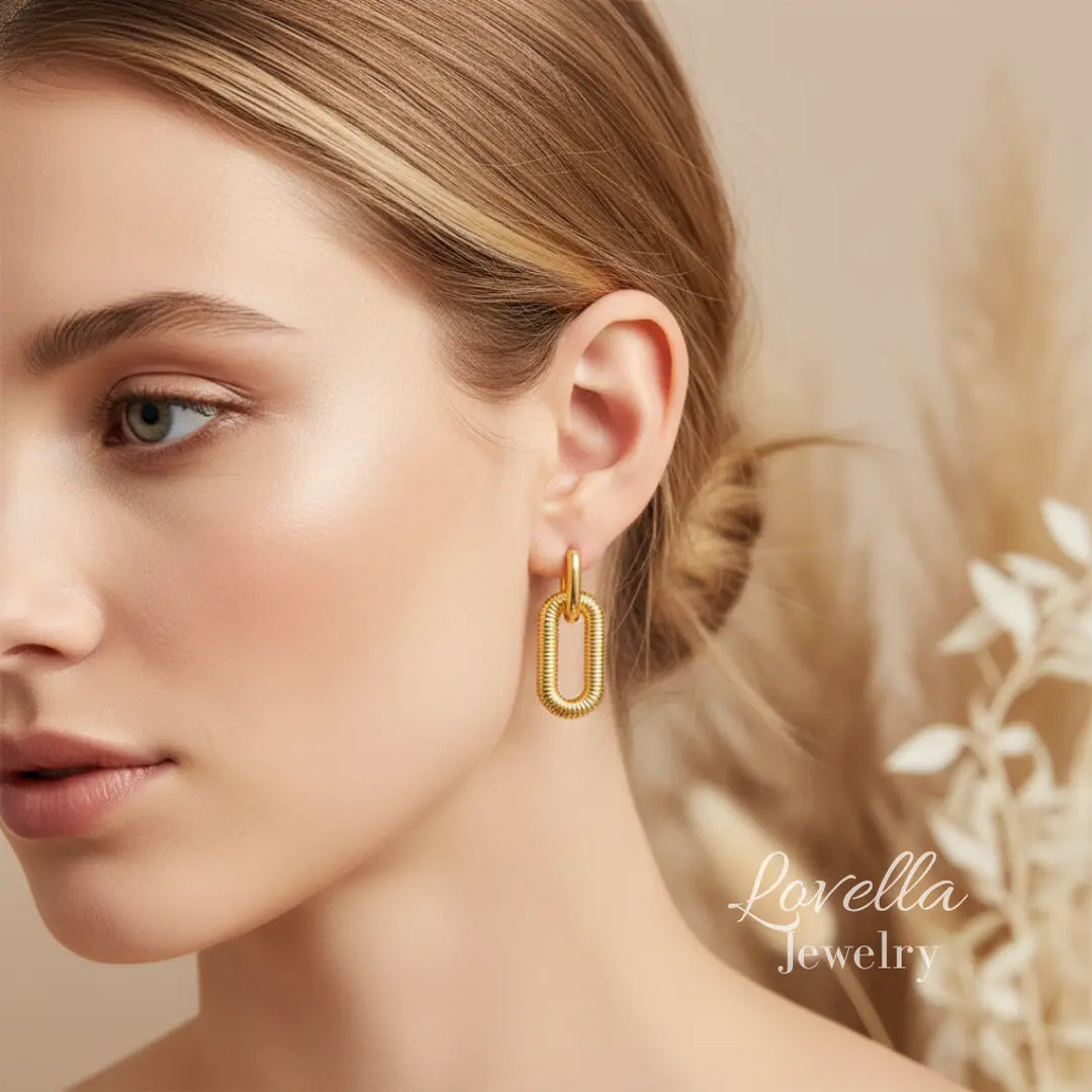 Woman wearing gold hoop earrings with a soft background and 'Lovella Jewelry' branding.