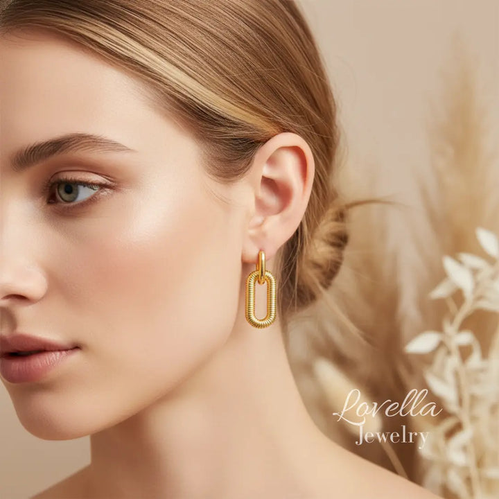 Woman wearing gold hoop earrings with a soft background and 'Lovella Jewelry' branding.