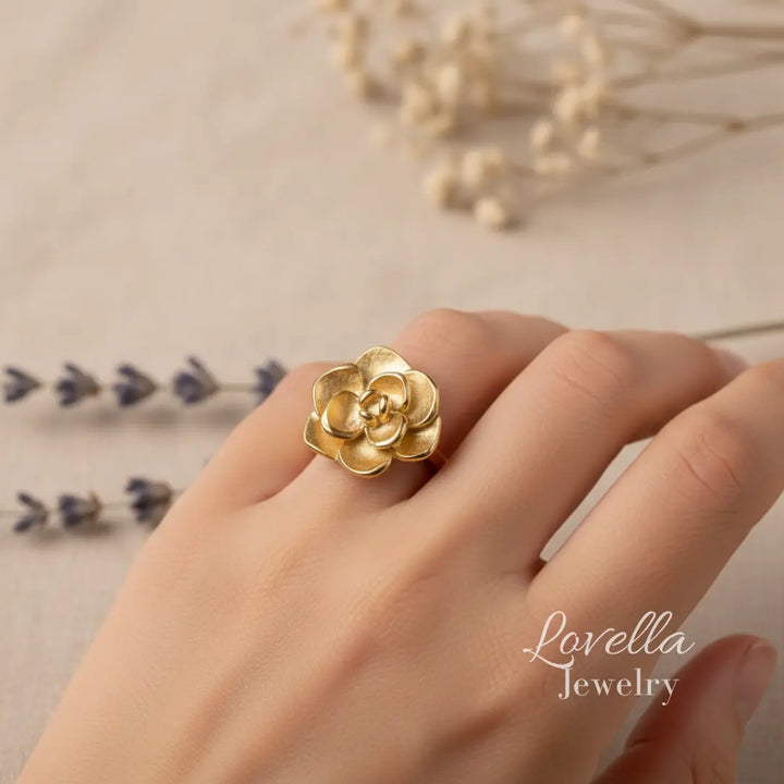 Gold flower ring on a hand with 'Lovella Jewelry' branding.