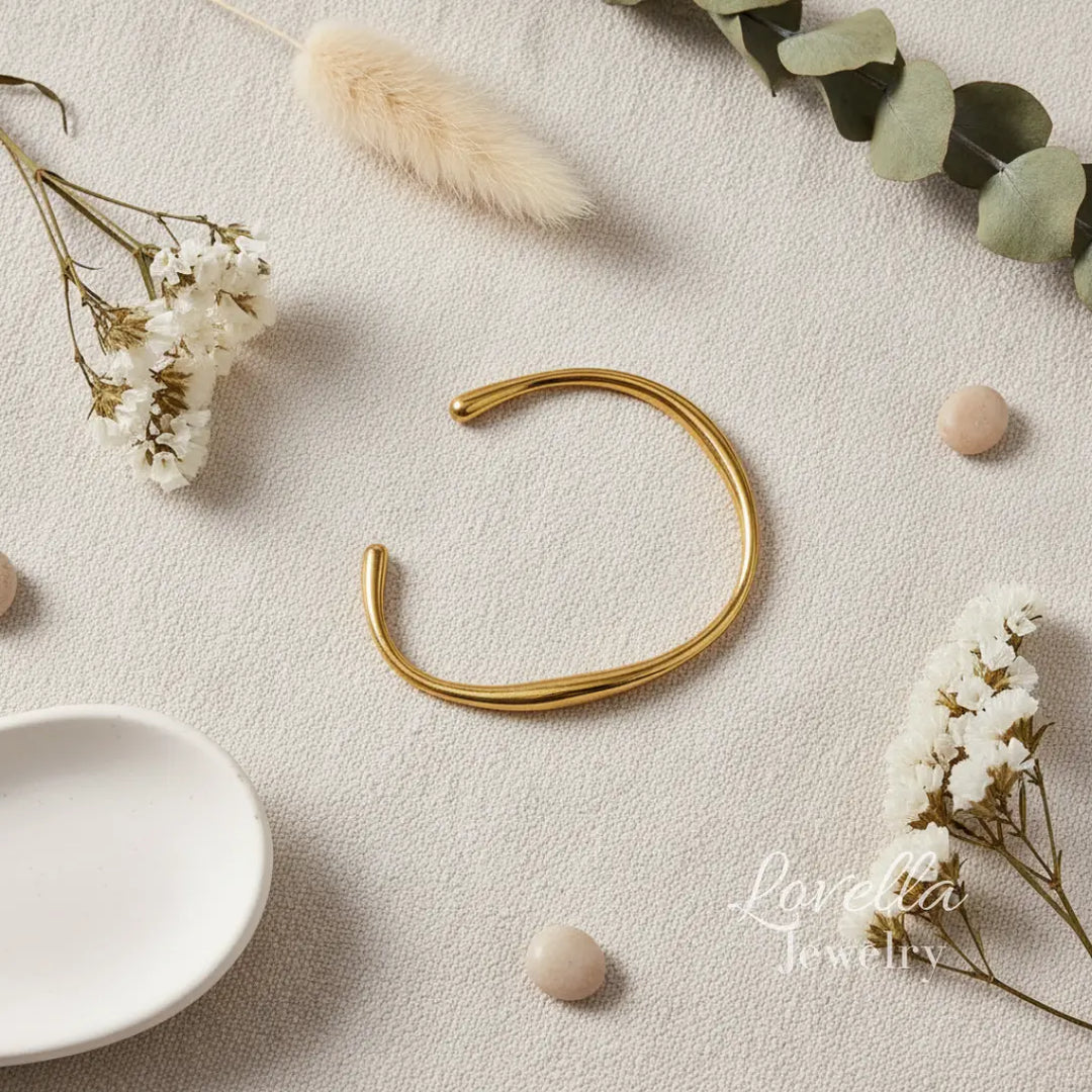 Gold bracelet on a light surface with decorative elements and 'Lovelisa Jewelry' branding.