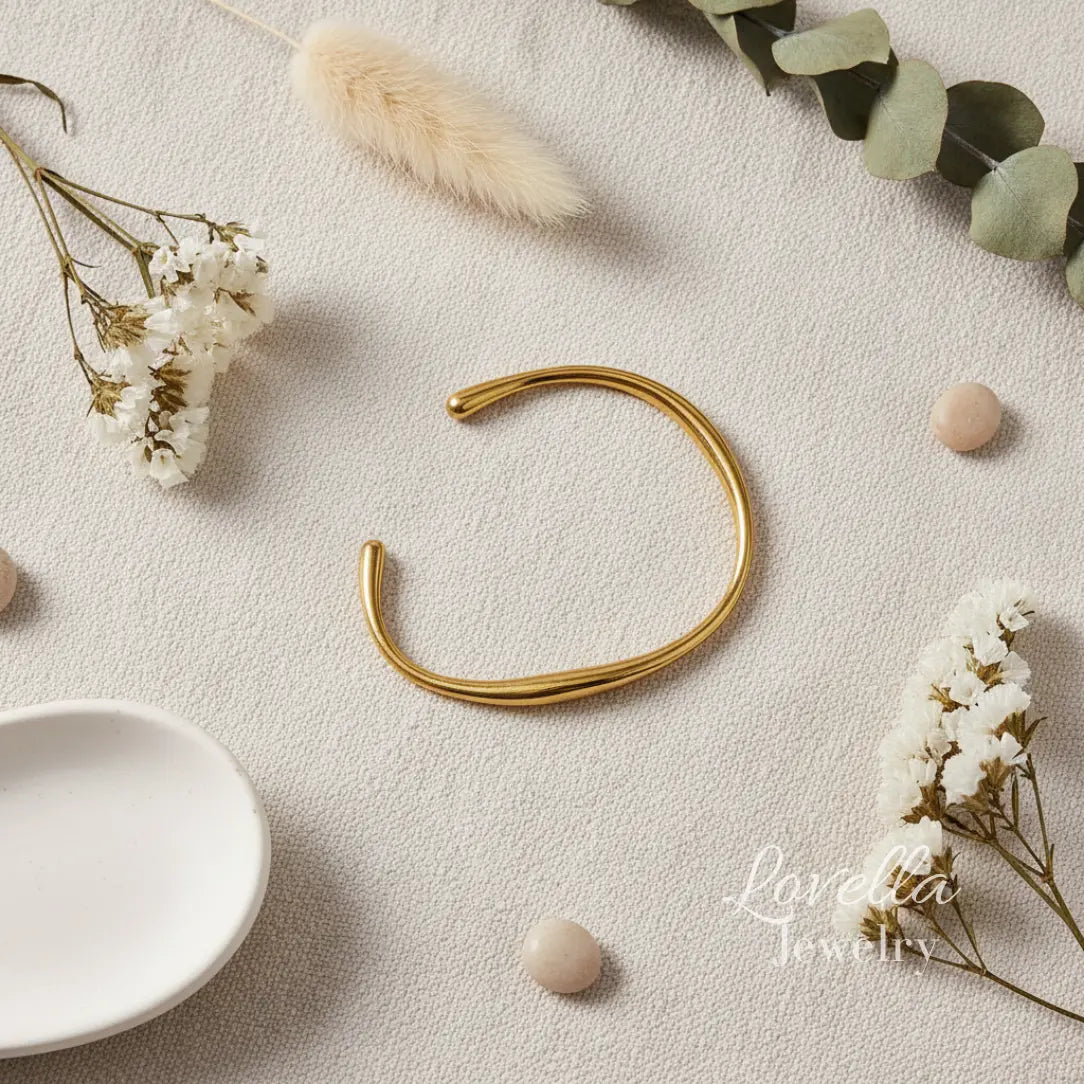 Gold bracelet on a light surface with decorative elements and 'Lovelisa Jewelry' branding.