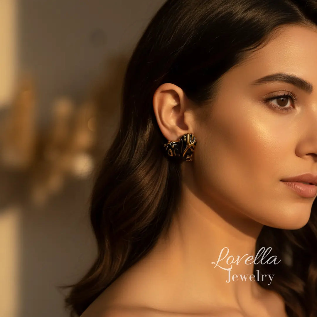 Woman wearing a gold earring with 'Lovella Jewelry' branding.