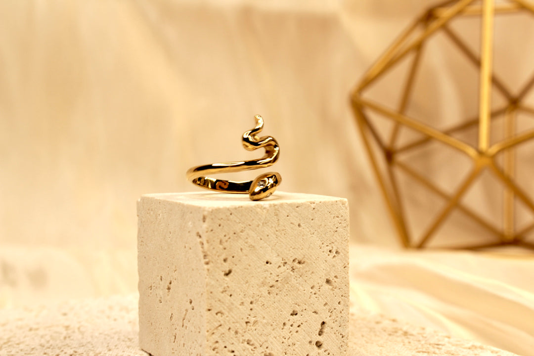 Anillo serpentino dorado con detalles de cristal