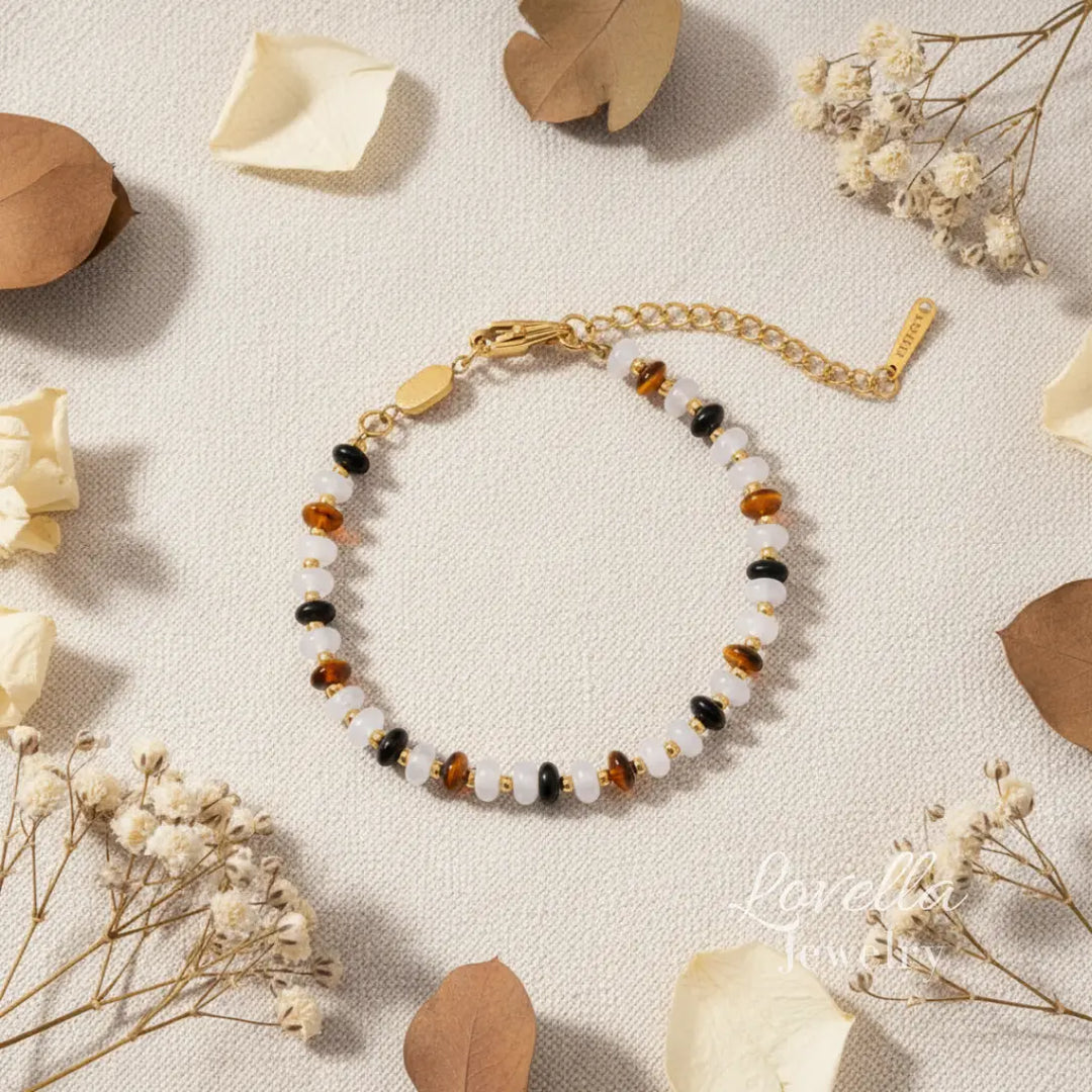 Bracelet with multicolored natural stones on a light background with dried flowers and leaves