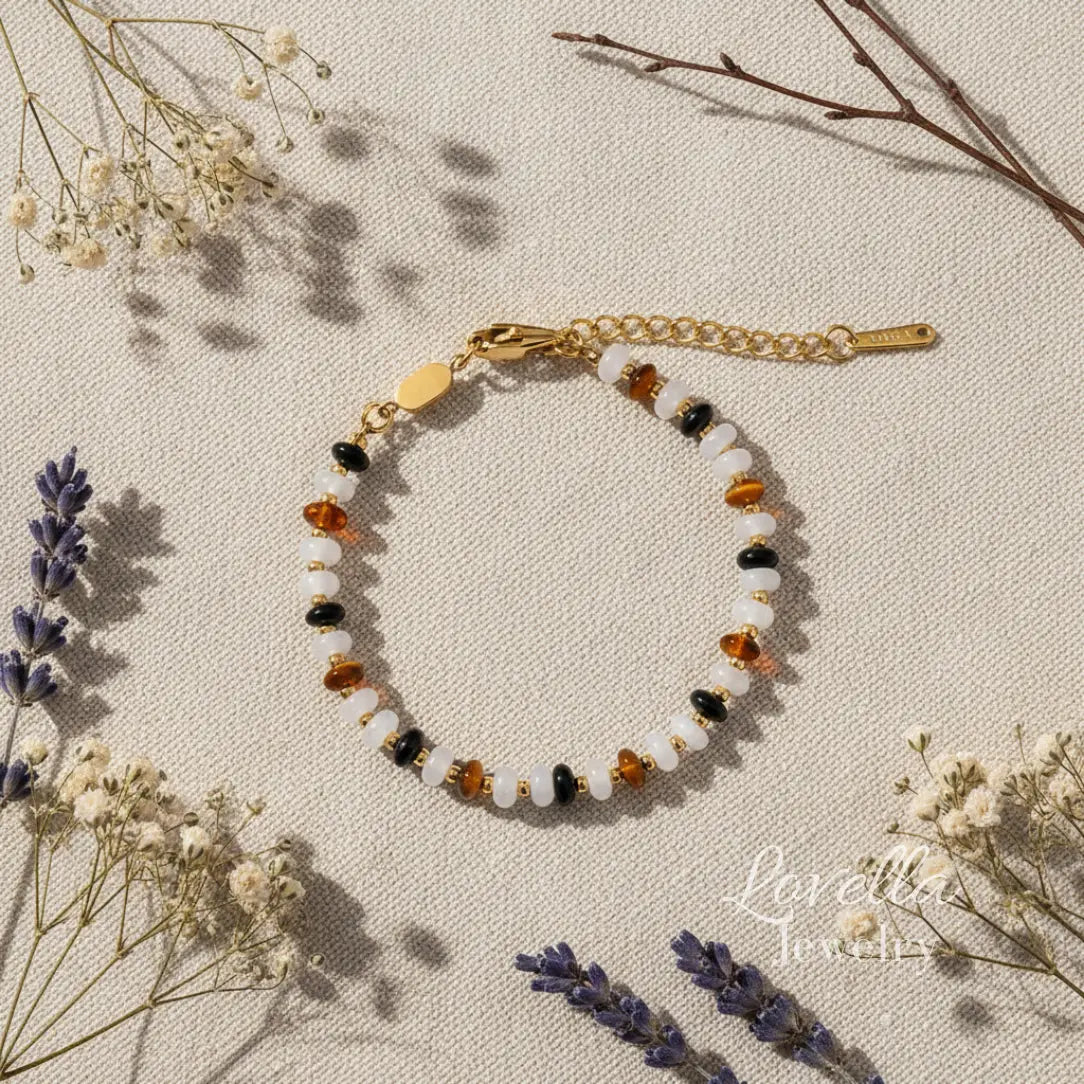 Bracelet with multicolored natural stones on a beige surface with dried flowers