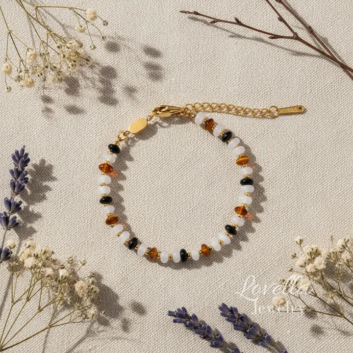 Bracelet with multicolored natural stones on a beige surface with dried flowers