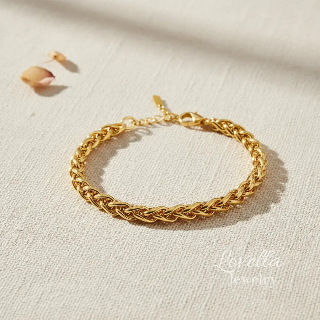 Gold chain bracelet on a light beige fabric background
