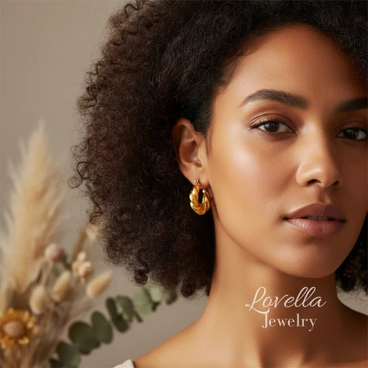 Woman wearing gold earrings with a neutral background and 'Lovella Jewelry' branding.