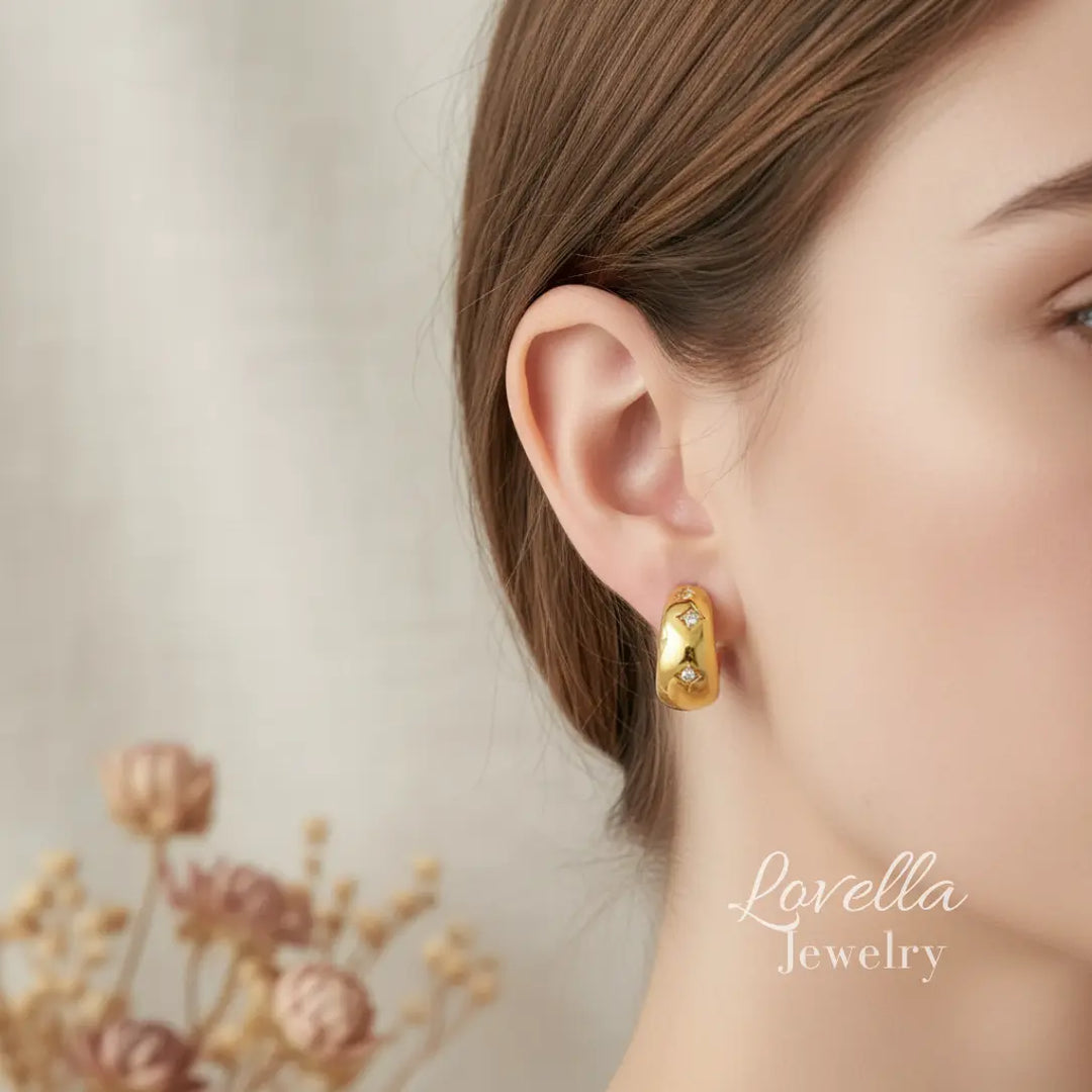 Gold hoop earrings worn by a model with 'Lovella Jewelry' branding.