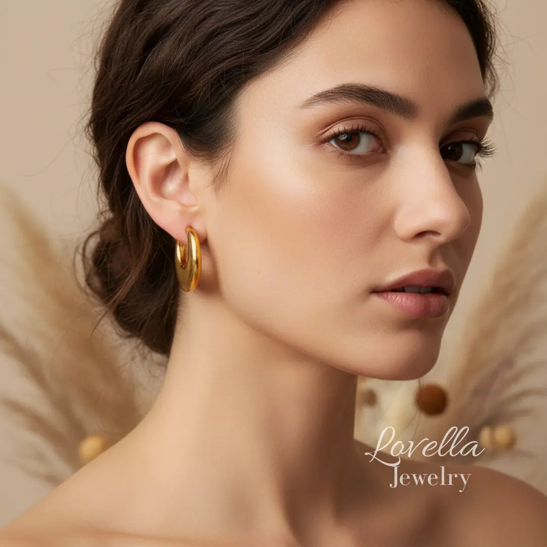 Woman wearing gold hoop earrings with 'Lovella Jewelry' branding.