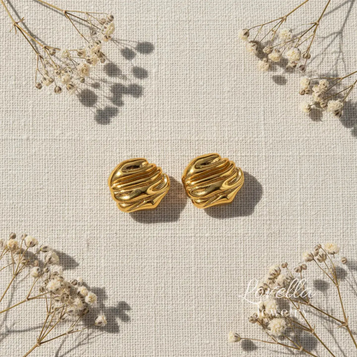 Gold chunky swirl stud earrings on cream linen background with dried flowers and Lovella Jewelry logo