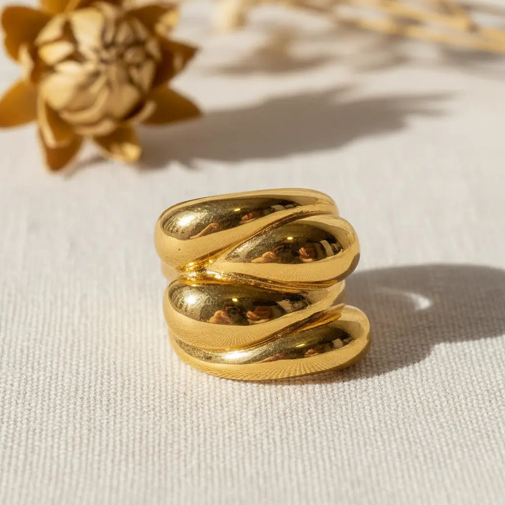 Gold ring with a textured design on a light background