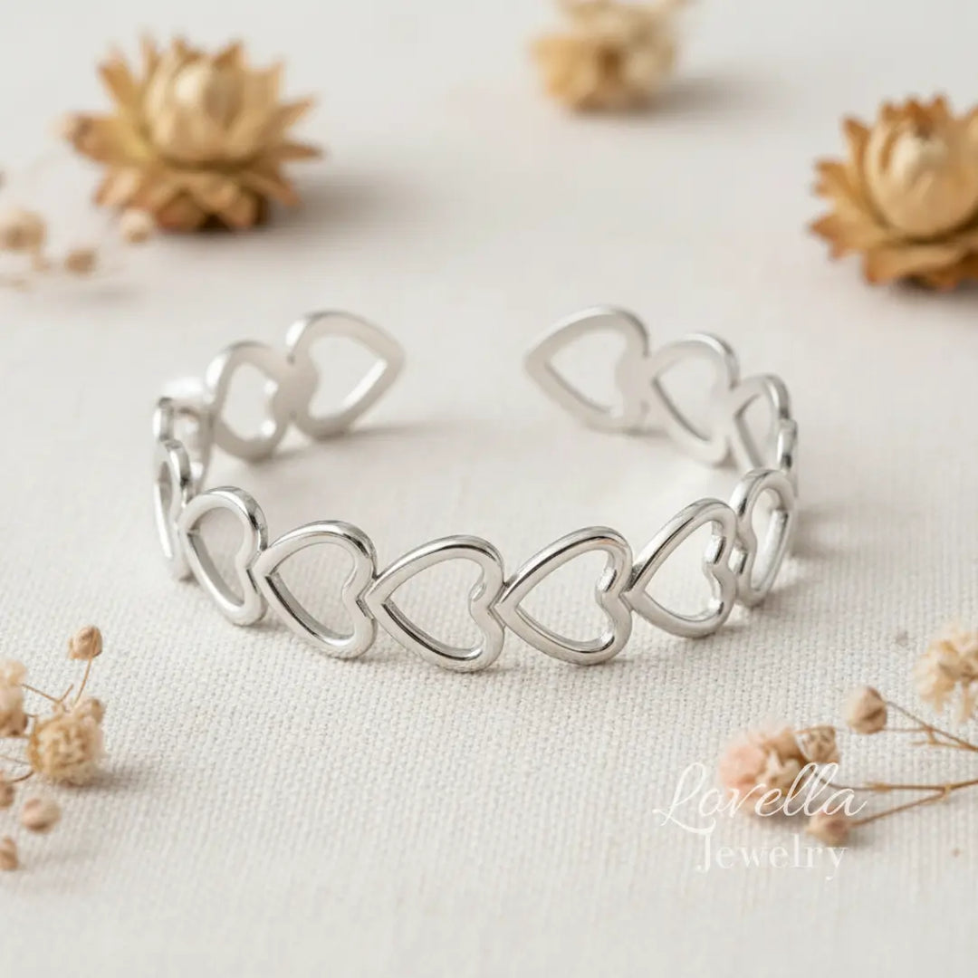 Silver heart-shaped bracelet on a light background with dried flowers.