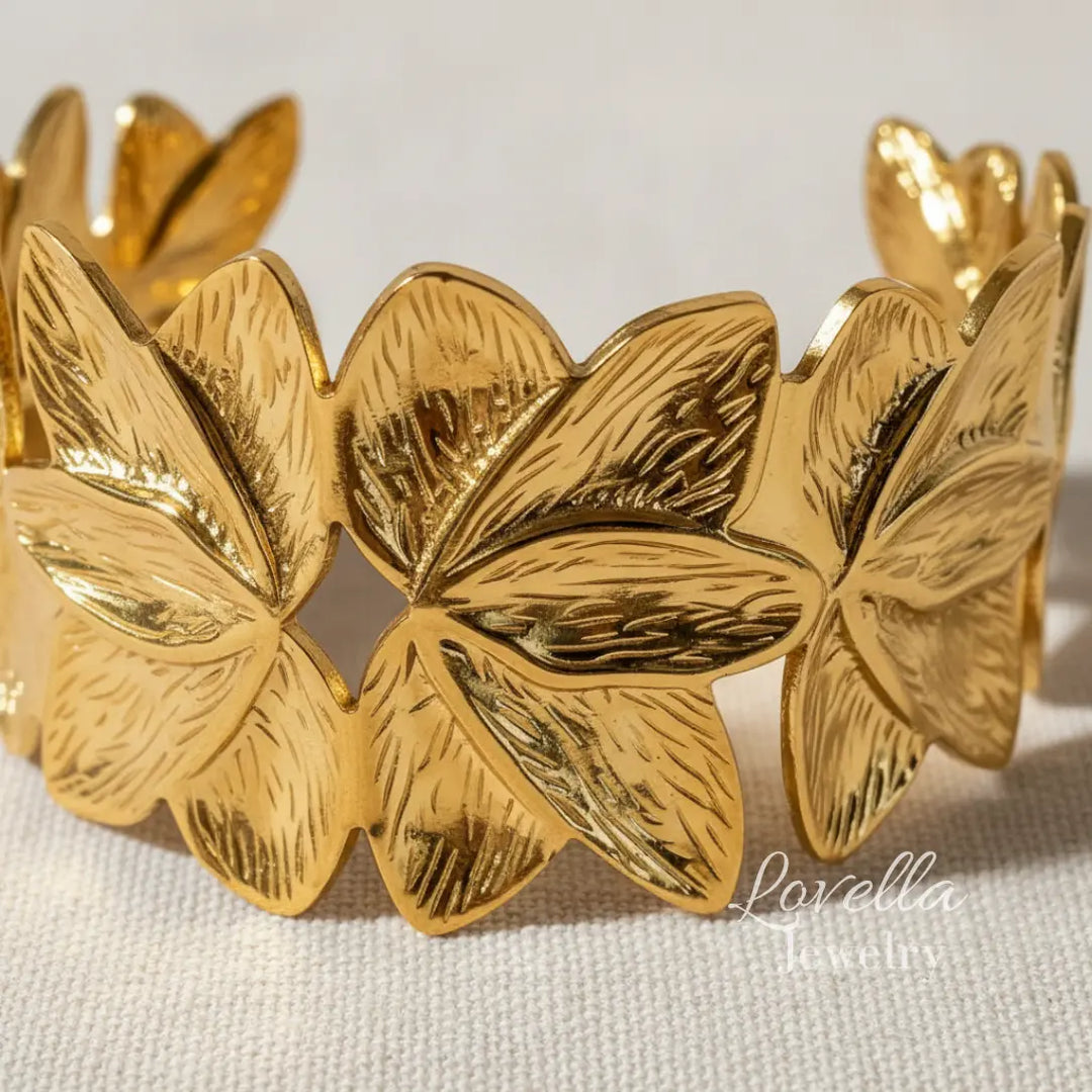 Gold bracelet with leaf design on a light background