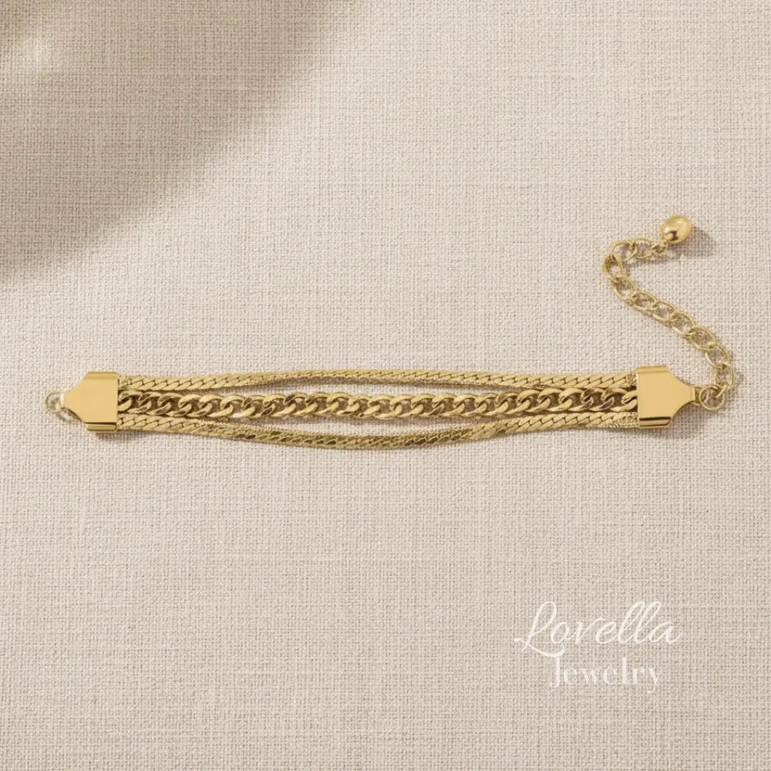 Gold chain bracelet on a beige fabric background with 'Lovella Jewelry' branding.