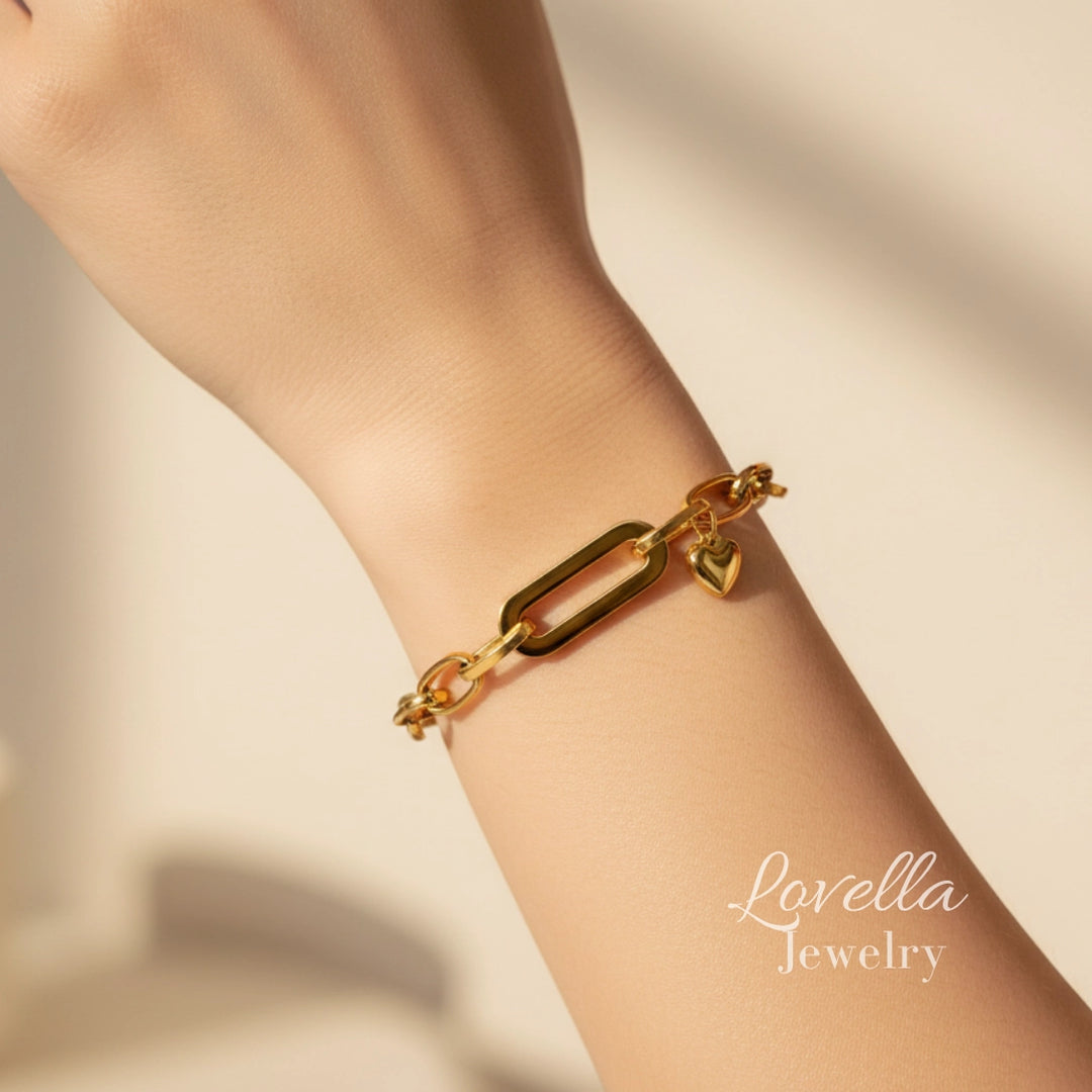 Gold bracelet on a wrist with 'Lovella Jewelry' branding on a beige background