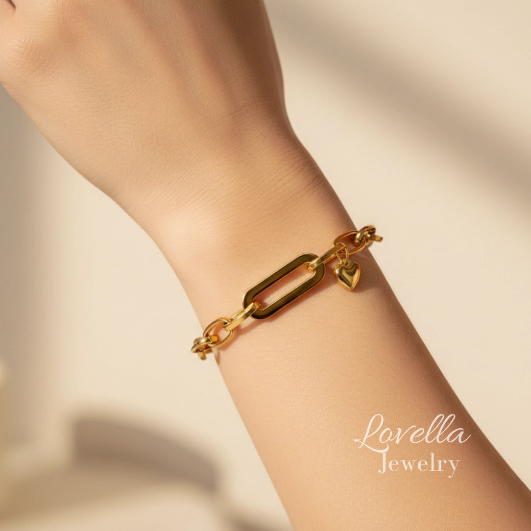Gold bracelet on a wrist with 'Lovella Jewelry' branding on a beige background