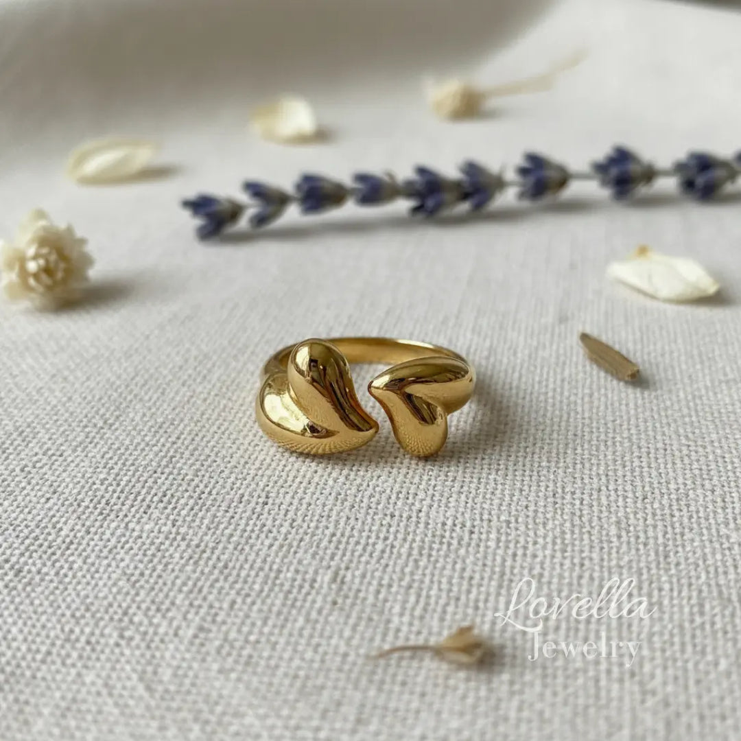 Gold ring on a textured surface with flowers in the background
