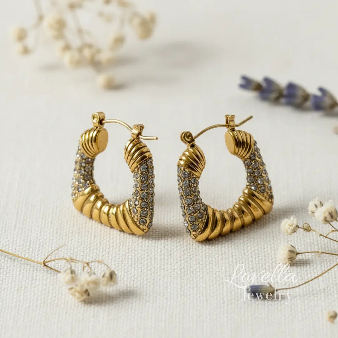 Gold hoop earrings with intricate design on a light background