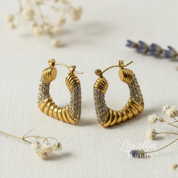 Gold hoop earrings with intricate design on a light background